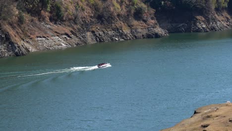 A-high-angle-view-of-a-power-boat-taking-a-load-of-tourists-on-a-cruise-around-Kulekhani-Lake-nearby-Markhu-town-in-Nepal