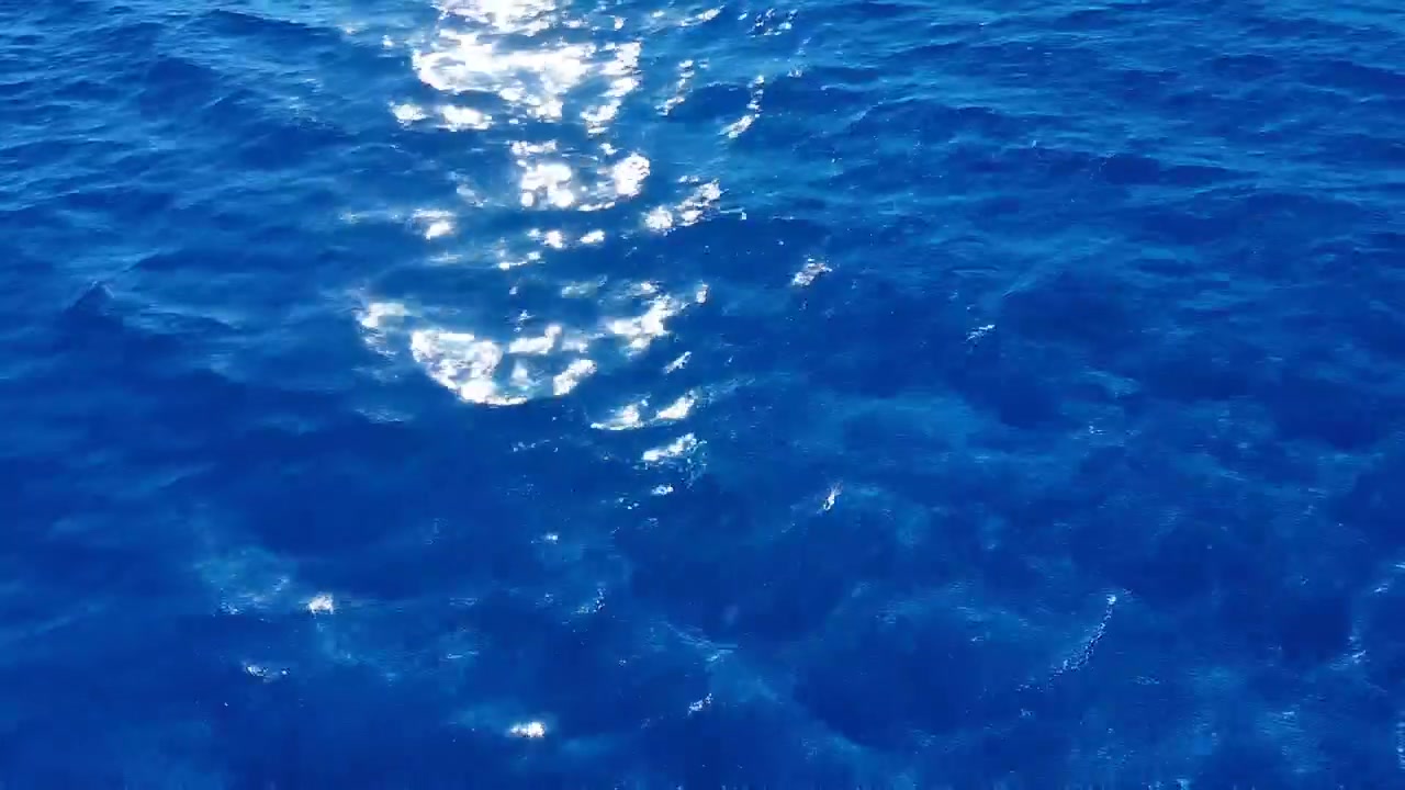 Sprankelend zonlicht reflecteert op diepblauw oceaanoppervlak
