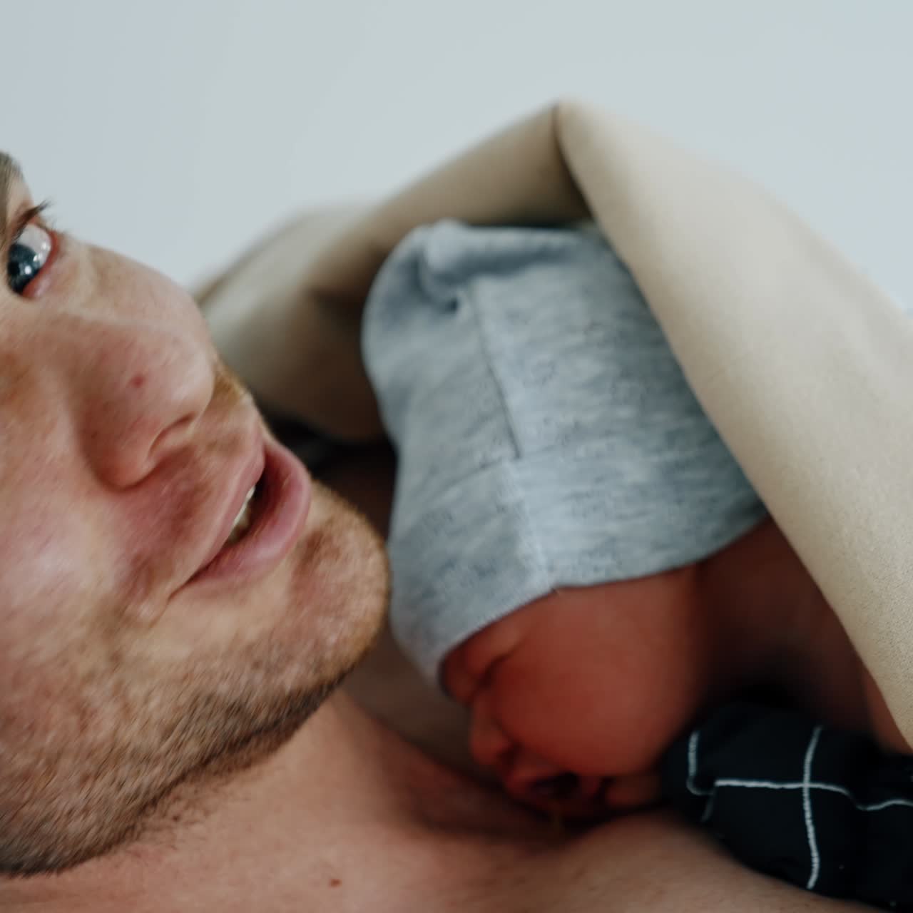 Glædelig kaukasisk far holder sin lille baby ind til brystet. Hud-mod-hud kontakt for nyfødte, efter at mor har fået foretaget kejsersnit. Tæt på