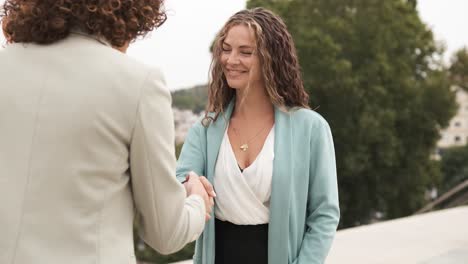 happy adult female business colleagues greeting in city