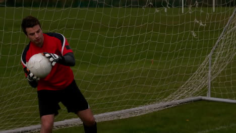 goalkeeper in red saving a goal during a game