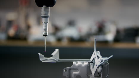 una máquina de medición de precisión cnc que prueba un producto metálico si está en los parámetros de calidad en la fábrica automatizada