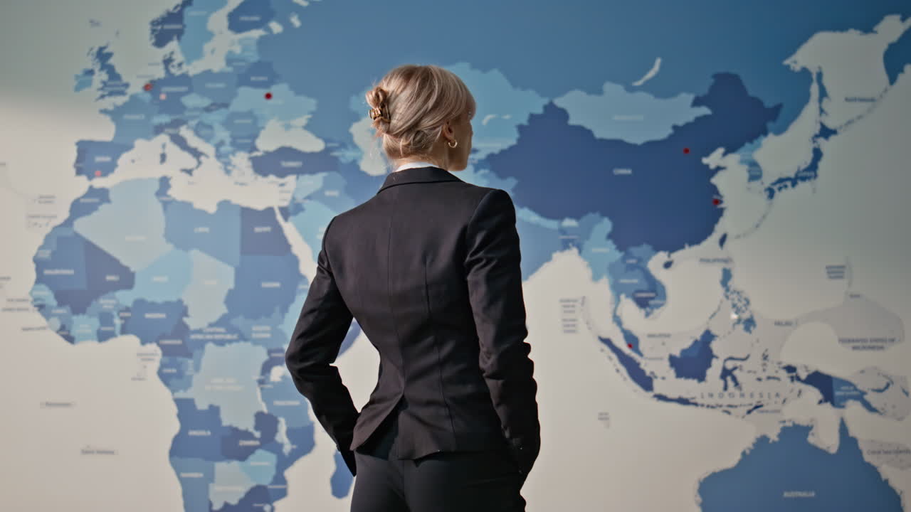Director estimating world map back view. Woman worker analyzing global economy