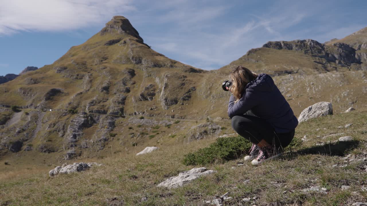 A woman photographer clicking pictures of mountain landscape