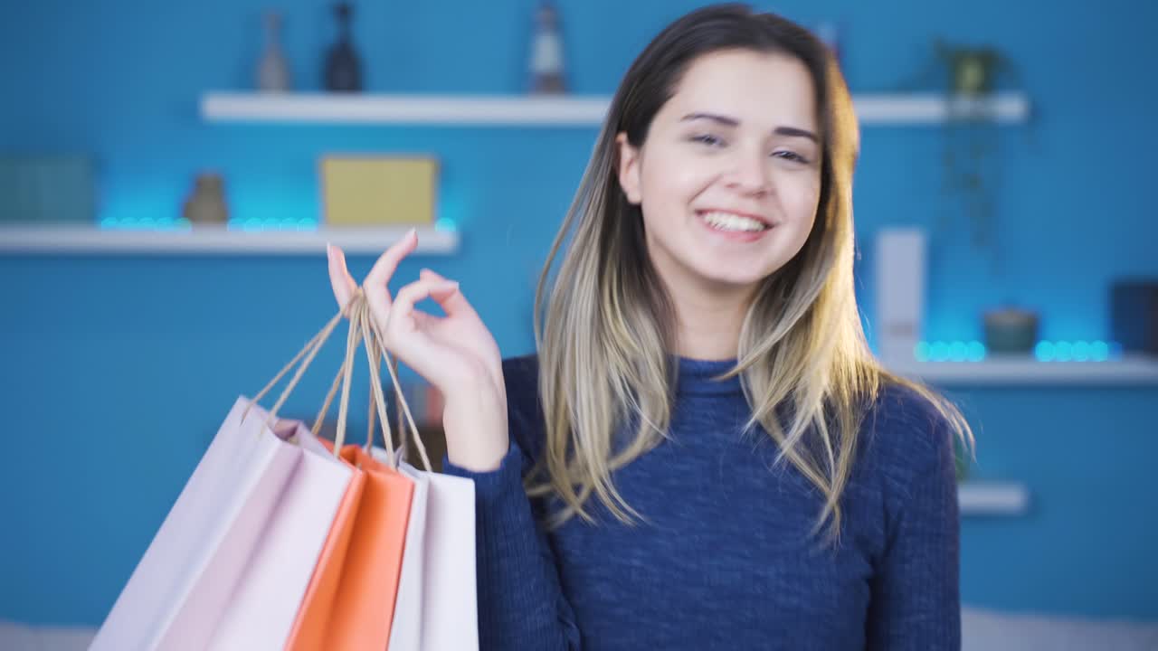una joven feliz y juguetona mira las bolsas de compras mientras baila.