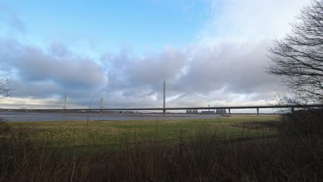 speeding clouds moving above motorway suspension bridge over river mersey estuary