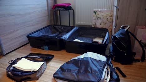 unrecognizable woman in sweatshirt packing clothes in a suitcase for travel