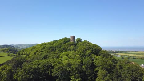 aerial view of the dunster conygar tower and surrounding areas full of trees near dunster castle, somerset, england.