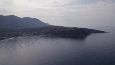 Antena-Sobre-El-Mar-Jónico-En-Calma-Con-La-Costa-Himare-Y-Las-Montañas-De-Fondo-En-Albania