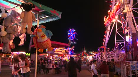 a carnival at night with prizes in the foreground