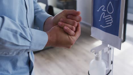 hombre de negocios usando desinfectante para desinfectar las manos cuando entra en el lugar de trabajo