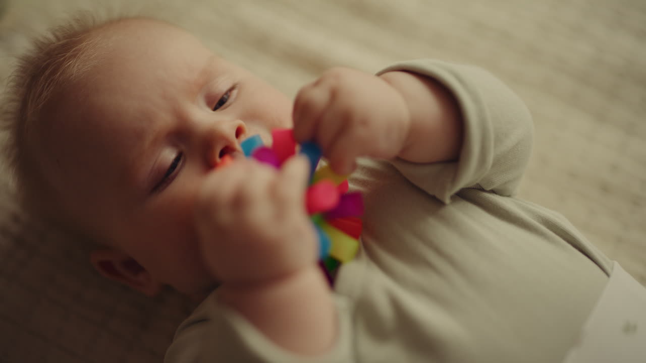 Close-up of Newborn Boy Playing with Toy