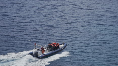 boat filled with tourists travels down the rugged coast of madeira portugal