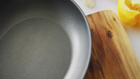 Video-of-fresh-vegetables-and-nuts-around-frying-pan-with-copy-space-on-wooden-background