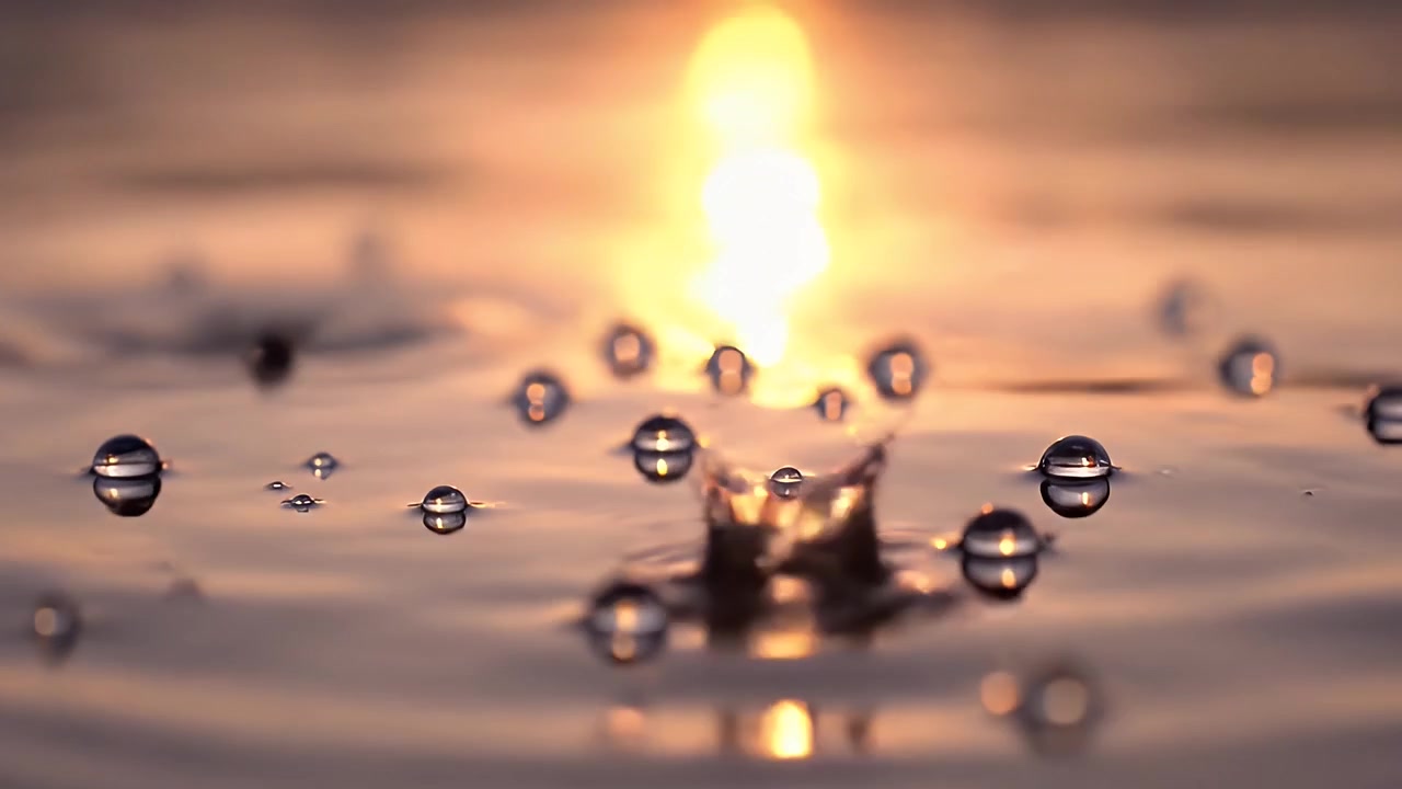 Raindrops Falling Into Calm Water at Sunset