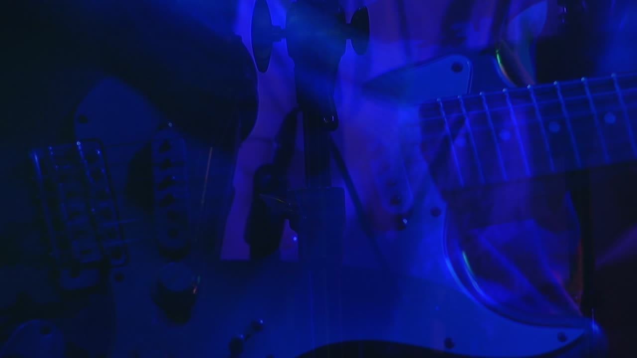 Animazione di forme blu su un musicista che suona la chitarra