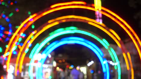 entrance in amusement park at night, colorful light of modern attractions as background.