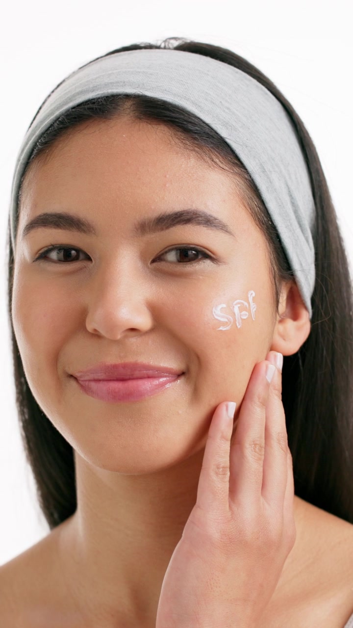 Young Woman Applying Sunscreen to Her Face