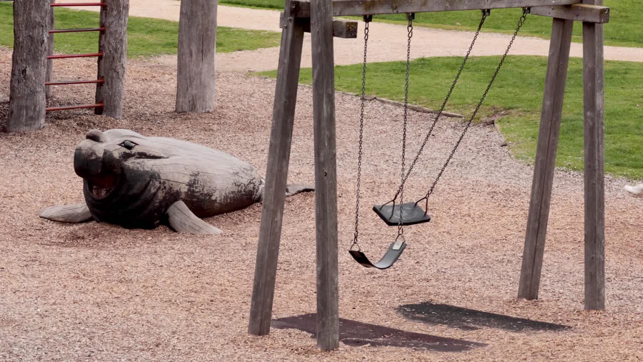 columpios que se mueven cerca de una escultura de foca