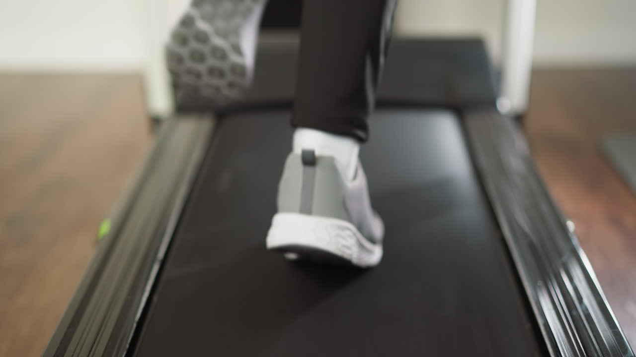 가정 트레드밀 클로즈업에서 스프린트하는 여성, 운동 신발을 입은 스포츠 여성, 실내 트레이닝 기기에서 조을 하는 여성, 슬로우 모션