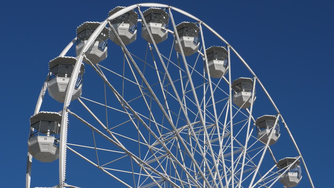 колесо обозрения в действии против голубого неба.