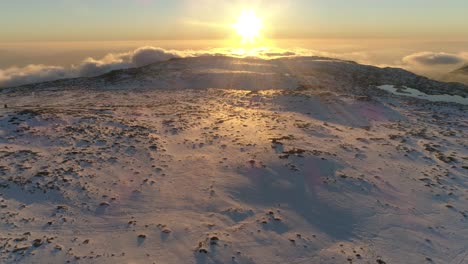 volando sobre las montañas en invierno al atardecer