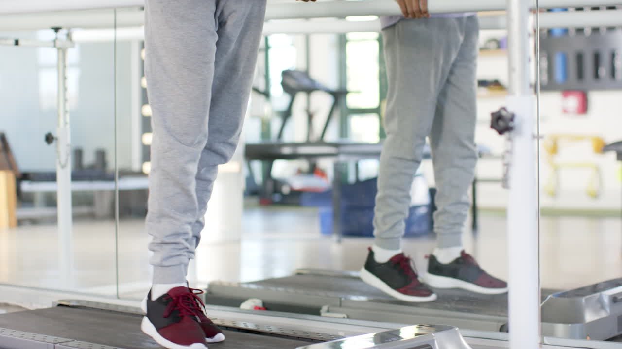 Man in rehabilitation center walking using parallel bars for physical therapy