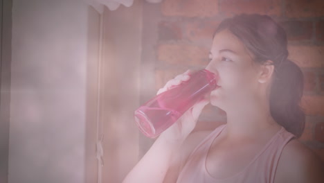 animation of flickering lights over woman drinking water during exercise at home