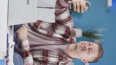 vertical video of home office worker man talking on the phone facetime happily.