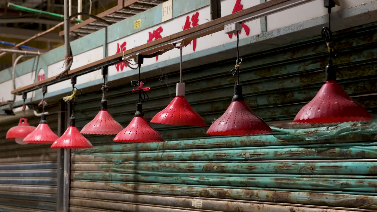 Red lanterns glow at a closed stall in a Hong Kong wet market late at night, highlighting traditional Chinese market decorations.