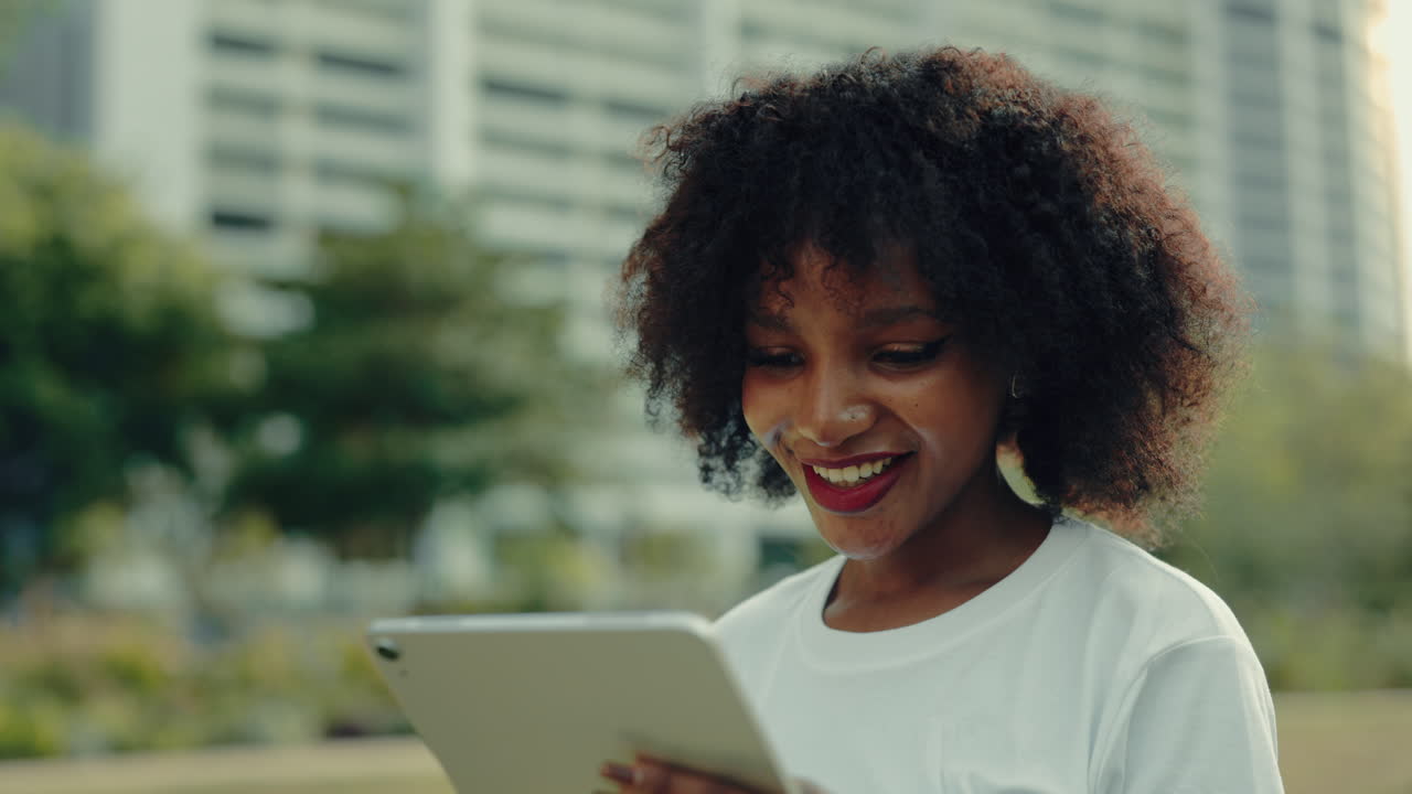 Young Woman Using Tablet in Park