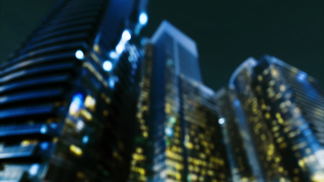 City skyline illuminated at night with modern buildings reflecting lights