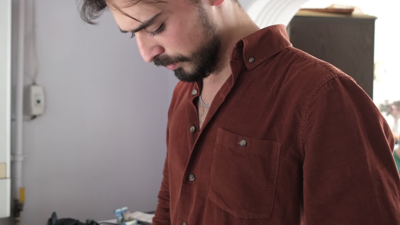 Young man getting dressed and looking good, guy straightening his shirt collar in front of a public mirror