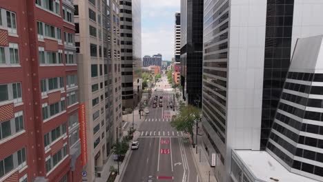 drone flying in denver downtown between city skyscrapers, sunny day in united states