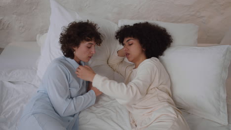 una pareja feliz hablando en la cama.