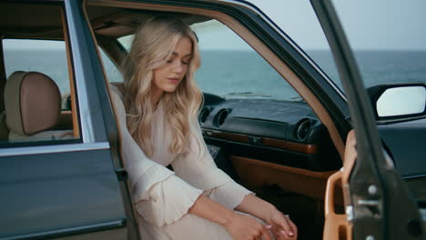 beautiful woman enjoy roadtrip sitting retro car at seashore. girl posing auto.