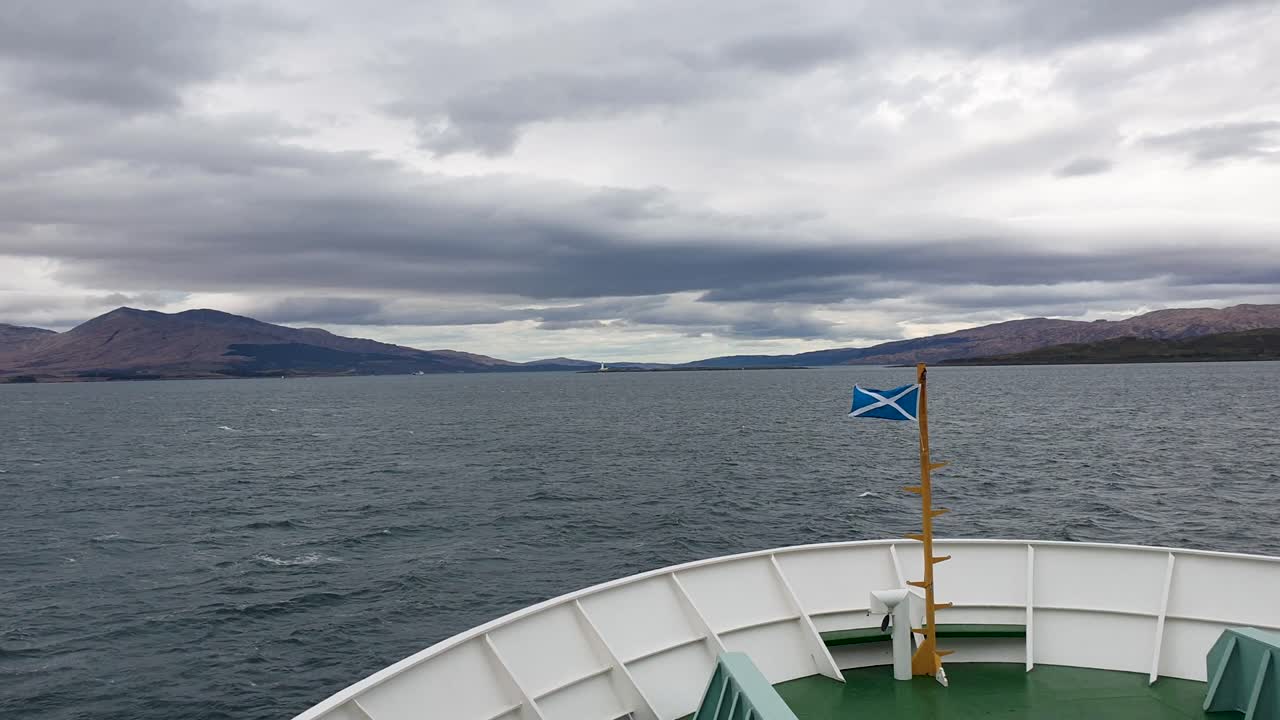 View from a Ferry with Scottish Flag and Mountains on a Cloudy Day