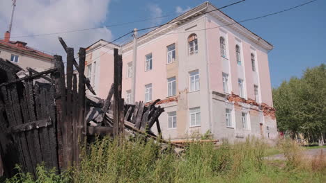 burnt building next to a pink building