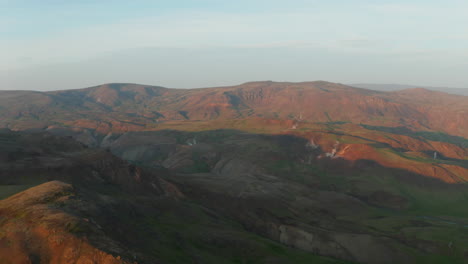 Flying-toward-drone-view-spectacular-iceland-highlands-at-sunset.-Aerial-view-drone-point-of-view-of-scenery-nordic-landscape-with-hill-and-mountains-covered-by-moss