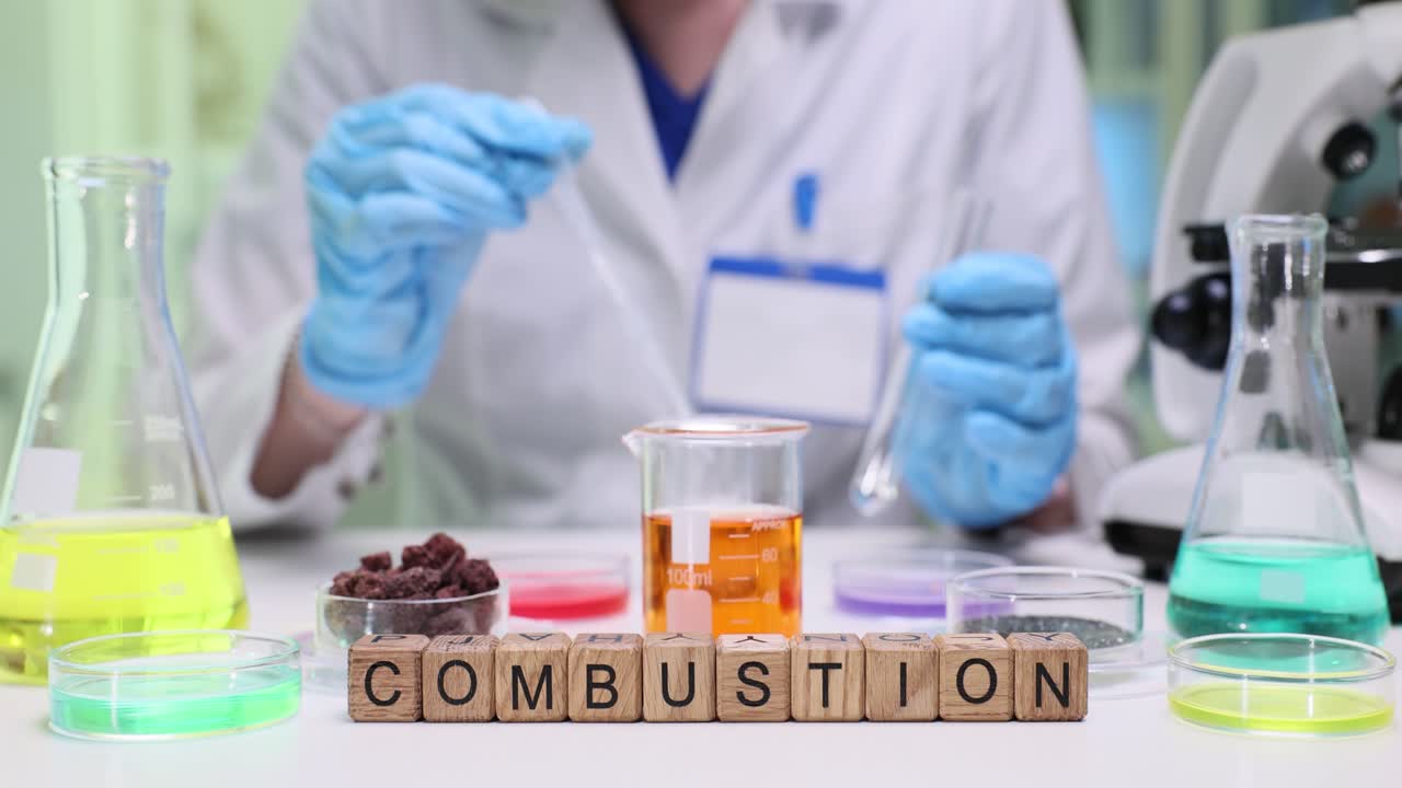 Cubos de madera deletrean combustión en escritorio de laboratorio con microscopio