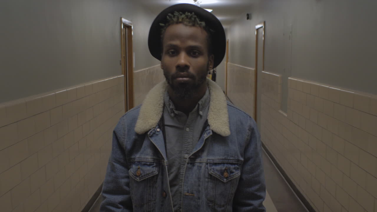 African American male slowly walking through a hallway