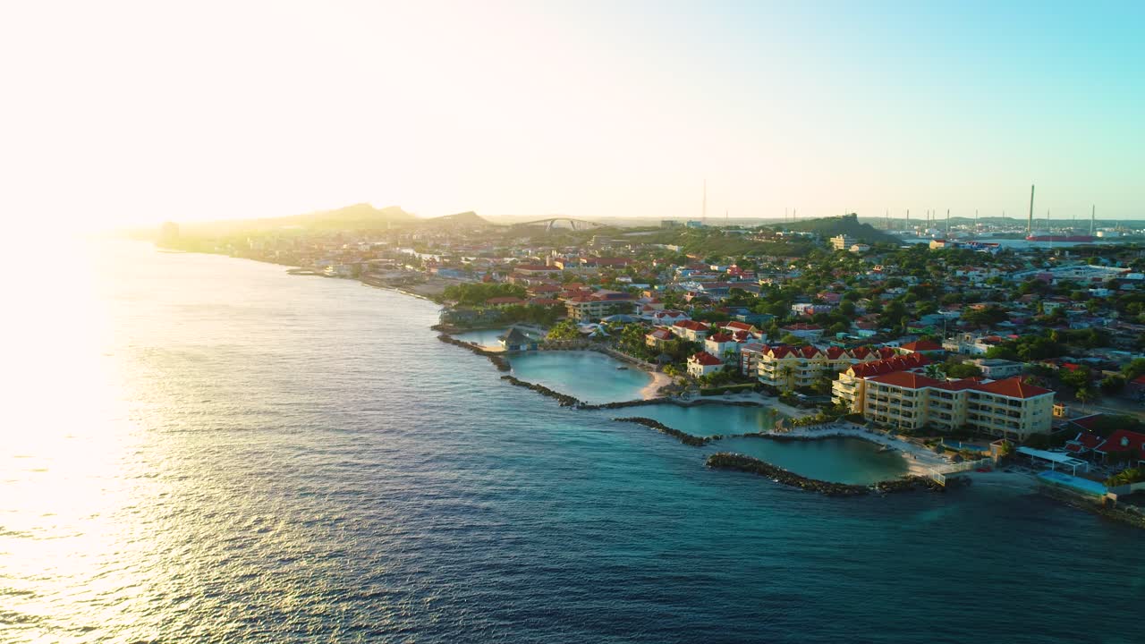 Gyllen time-glød ved solnedgang over hotellaguner for ferieopphold i Willemstad, Curaçao