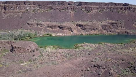 el aire desciende al verde vívido de los acantilados del lago profundo en wa scablands