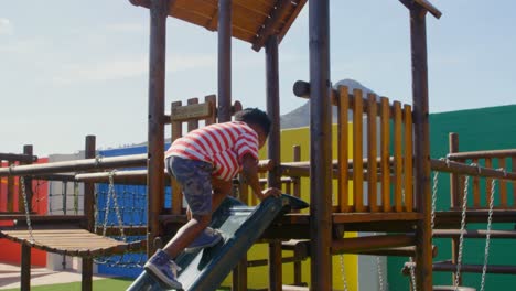 Vista-Lateral-De-Un-Colegial-Afroamericano-Jugando-En-Toboganes-En-El-Patio-De-La-Escuela-4k