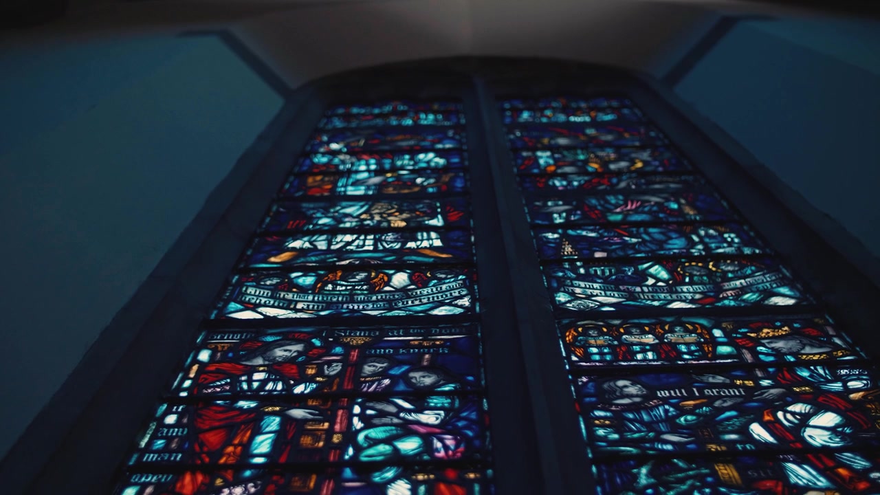 Panoramica verso l'alto di una vetrata alta e colorata in una chiesa