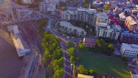 vista aérea en movimiento hacia atrás de una calle de la ciudad y un puente al atardecer