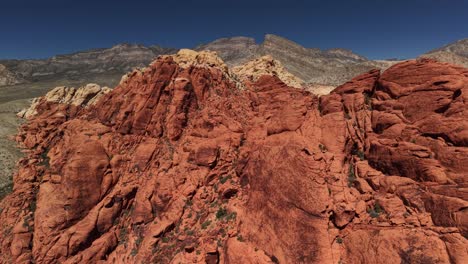 This close-up aerial perspective showcases the incredible details, textures, and vibrant colors of the rocks, highlighting the geologic masterpiece of Red Rock Canyon