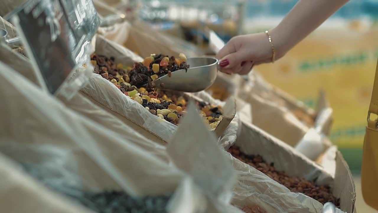 Young girl pours dried fruit into a package