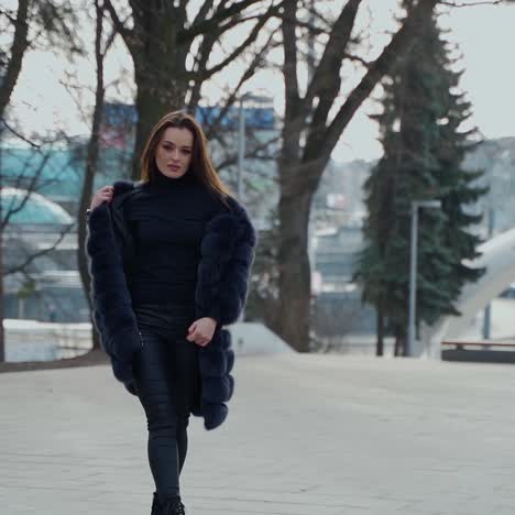 fashion outdoor video of a sexy glamour woman with dark hair wearing luxurious fur coat in autumn park.