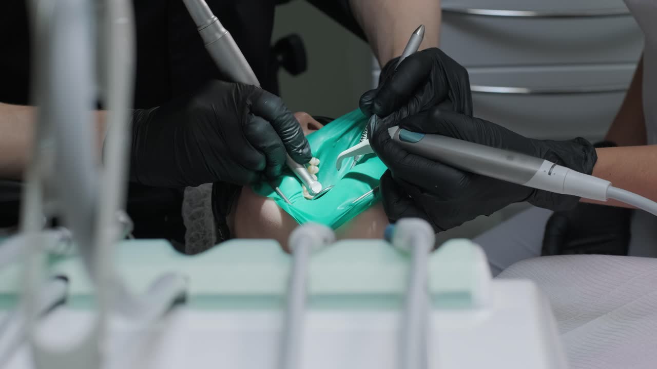 치과의사가 치과의사에서 환자의 치아를 검사합니다.